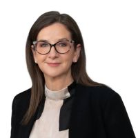 A corporate head shot of AER Chair, Clare Savage, looking at the camera, against a white background.