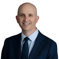 A head shot of Jarrod Ball, wearing a suit and smiling at the camera.