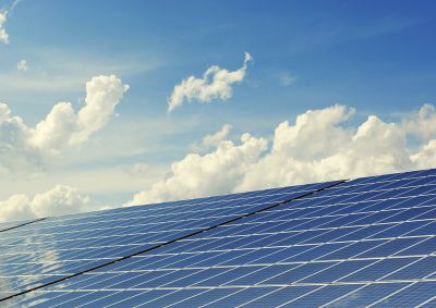 Solar panels on a roof with a cloudy sky in the background