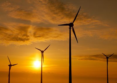 Wind turbines on a wind farm with the sun setting behind them