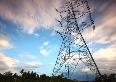 A photo of a transmission tower against a cloudly sky